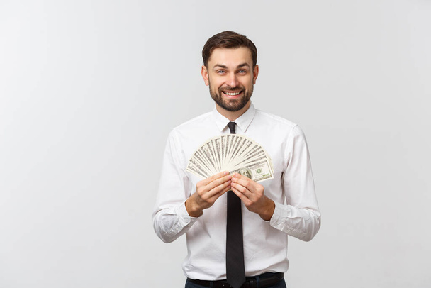 Closeup of cheerful young businessman holding money over white background. - Photo, Image