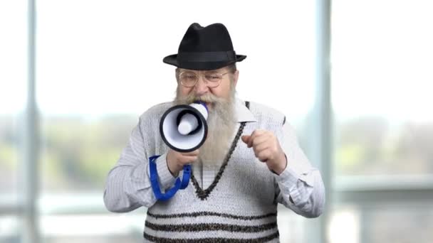 Oude man met baard moedigt spraak in megafoon aan. - Video