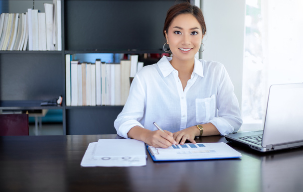 Beautiful Asian business women checking document and using notebook working from home for social distance and self responsibility concept - Foto, imagen