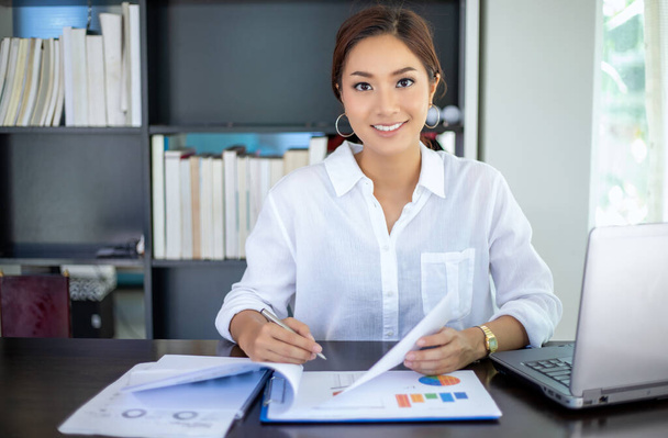 Belles femmes d'affaires asiatiques vérifier le document et en utilisant un carnet de travail de la maison pour la distance sociale et concept de responsabilité personnelle
 - Photo, image