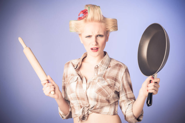 Épingler femme au foyer avec rouleau à pâtisserie et poêle
 - Photo, image