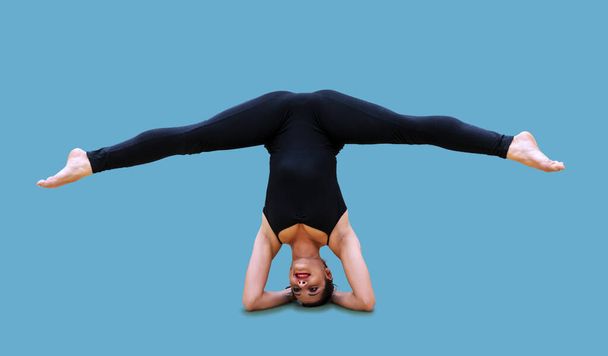 pretty millennial athlete who trains by performing synchronized exercises isolated on blue background - Foto, imagen