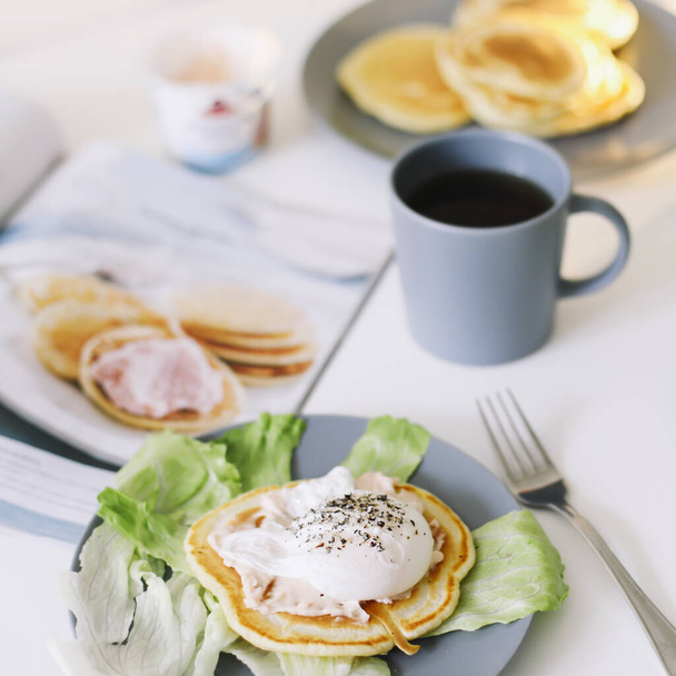 Healthy nutritious tasty breakfast. Pancakes, poached egg on ceramic plate and coffee cup. table setting. food photo. good morning - Foto, Imagem