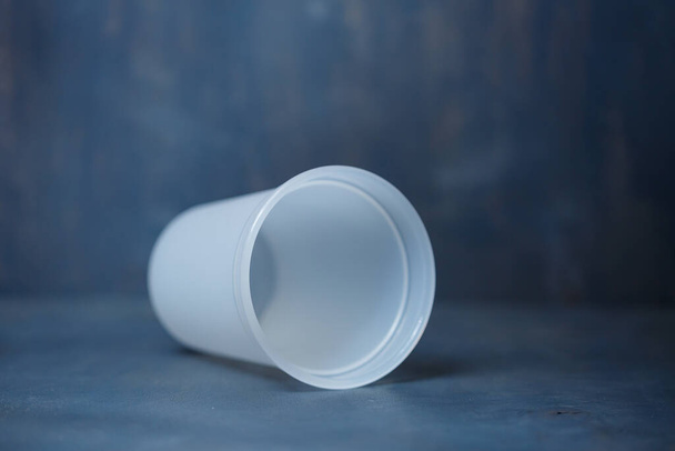 Plastic glass for mixing cream on a gray background - Valokuva, kuva