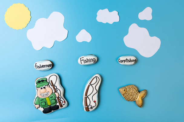 Colorful cartoon cookies on a fishing theme. Cookies in the shape of a fisherman and a fish. Homemade gingerbread cookie. - Photo, Image