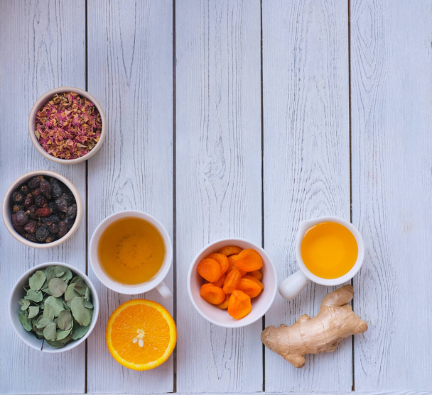 składniki wzmacniające odporność herbaty- zioła, imbir, pomarańcza, miód i róże jagody. - Zdjęcie, obraz