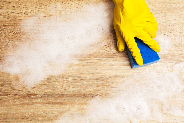 Close up of worker hand wiping dust in office in yellow gloves - Foto, Imagem