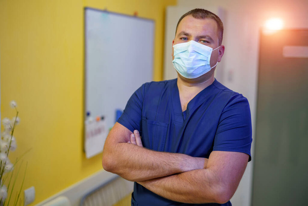 Confident successful doctor in hospital. Male in mask. Photo in medical office. - Foto, imagen