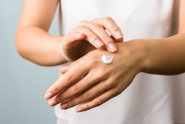 hand skin protection. close up view of woman hand applying moisturizer. - 写真・画像