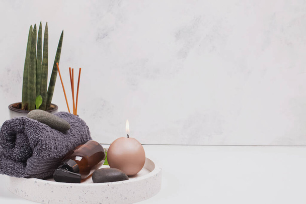 Облаштування спа-ванни зі свічкою, рушником, пляшковою олією та камінням
 - Фото, зображення