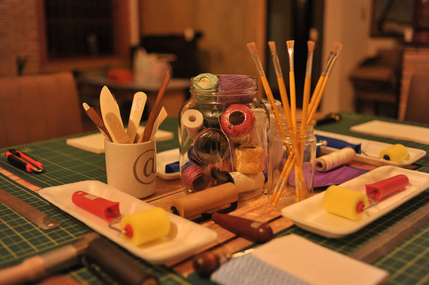 Mesa lista para el trabajo de artes y oficios con pinceles, reglas y costura.
. - Foto, Imagen