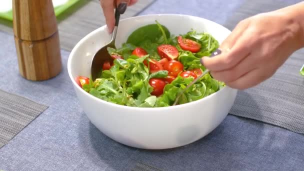 Tomato and green salad close-up, the moment of mixing the ingredients - Video