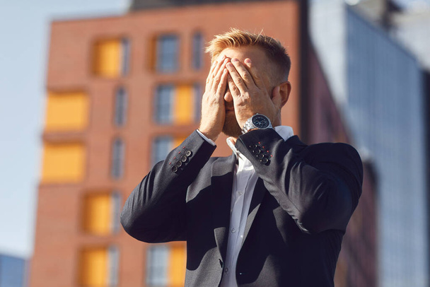 Crisis concept stress unemployment problem. Businessman covered his face with his hand - 写真・画像