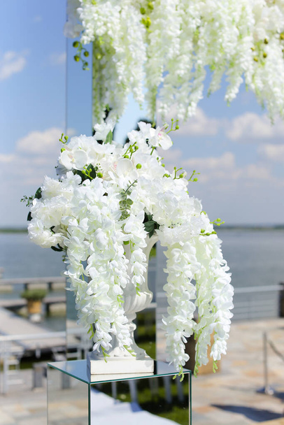 Arco de boda decorado con acacia blanca, lago en el fondo
. - Foto, imagen