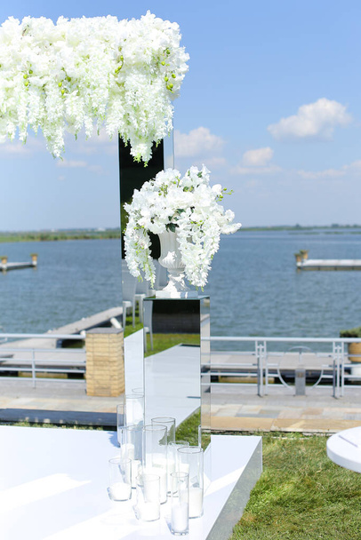 Blanco hermoso arco de boda con lago en el fondo
. - Foto, imagen