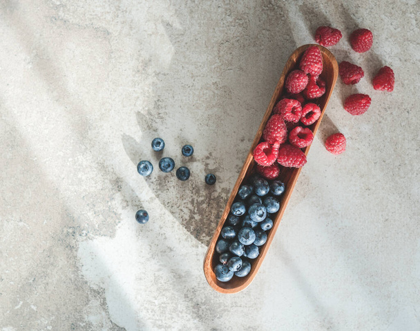Blueberries and raspberries in bowl on gray table, topview - Photo, Image