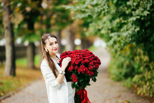 Woman with Spring Flower bouquet. Happy surprised model woman smelling flowers. Mother's Day. Springtime. - Foto, Imagen