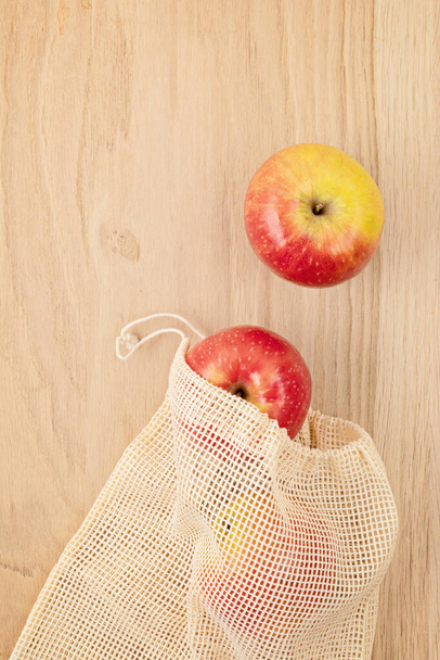 Flache Lage aus umweltfreundlicher wiederverwendbarer Baumwolltasche mit Äpfeln. Nachhaltiges, ethisches, plastikfreies und abfallfreies Lifestylekonzept. Ansicht von oben - Foto, Bild