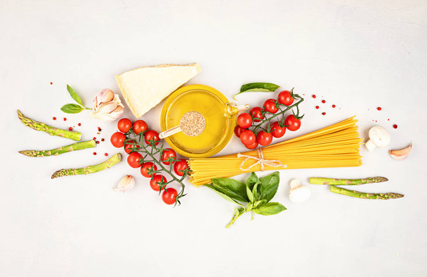 Плоская лепешка с традиционными пастой спагетти и кулинарными ингредиентами. Традиционная итальянская кухня. Вид сверху
 - Фото, изображение