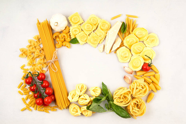 Vlak gelegd met verschillende soorten traditionele Italiaanse pasta. Penne, tagliatelle, fusilli, farfalle, spaghetti en kookingrediënten. Traditioneel Italiaans cusine concept. Bovenaanzicht - Foto, afbeelding