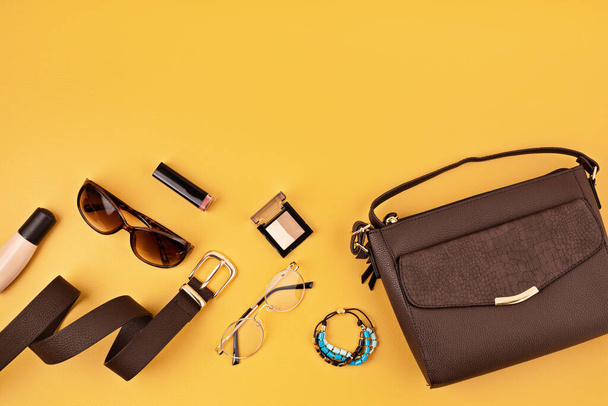 Flat lay with woman fashion accessories over yellow background. Fashion, online beauty blog, summer style, shopping and trends concept. Top view - Photo, Image