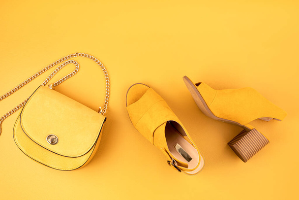 Flat lay with woman fashion accessories in yellow color over yellow leather textured background. Fashion, online beauty blog, summer style, shopping and trends concept - Photo, Image
