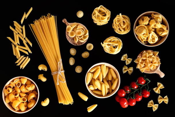 Vlak gelegd met verschillende soorten traditionele Italiaanse pasta. Penne, tagliatelle, fusilli, farfalle, spaghetti en anderen. Traditioneel Italiaans cusine concept. Bovenaanzicht - Foto, afbeelding