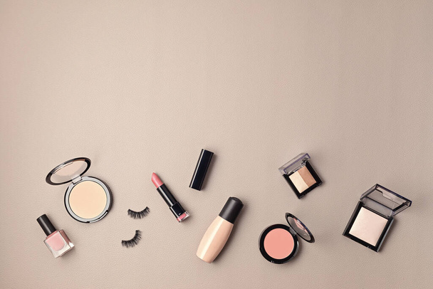 Flat lay with set of professional decorative cosmetics, makeup tools and woman accessories over gray background with copy space. Beauty blog, fashion, party and shopping concept. Top view - Photo, Image
