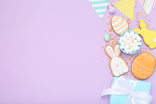 Easter gingerbread cookies with gift box, sprinkles and marshmallow on purple background - Foto, immagini