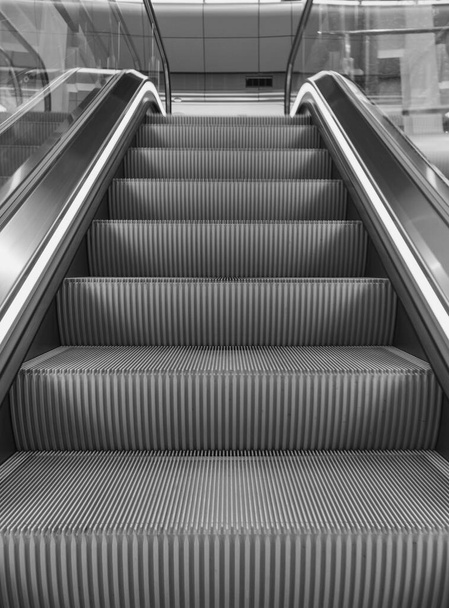 Havaalanı monokromunda boş yürüyen merdiven. Metrodaki yürüyen merdiven siyah beyaz. Elektrikli merdiven perspektifi. Ulaşım modu. Modern binada boş asansör.  - Fotoğraf, Görsel