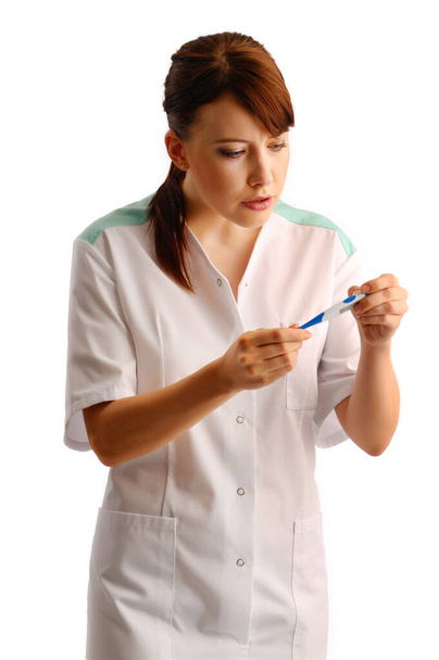 Portrait of medical assistant checking thermometer - Foto, afbeelding