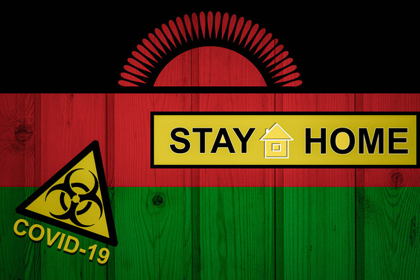 Flag of the Malawi in original proportions. Quarantine and isolation - Stay at home. flag with biohazard symbol and inscription COVID-19. - Photo, Image