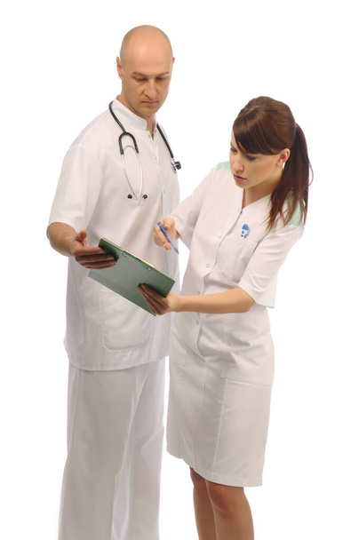 Zwei Arzthelferinnen besprechen Notizen über den Patienten - Foto, Bild