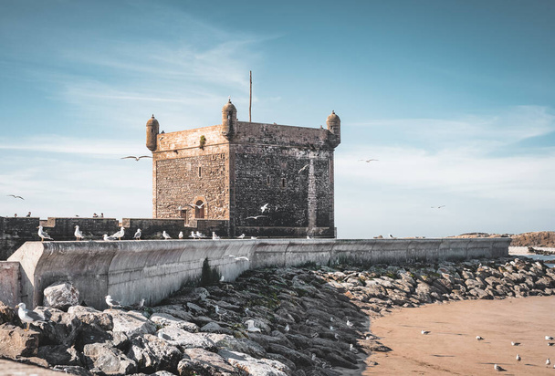 Sqala du Port, une tour défensive au port de pêche d'Essaouira, Maroc près de Marrakech. Ciel bleu avec nuages et vue sur la plage
. - Photo, image