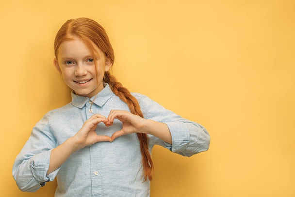 lovely caucasian girl show heart made from hands - Foto, Imagem