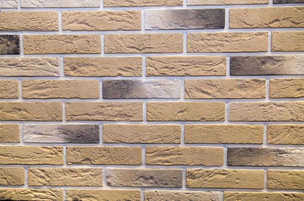 Background of artificial stone beige rectangular shape in the form of a wall of bricks. Backgrounds, textures, and design. - Φωτογραφία, εικόνα