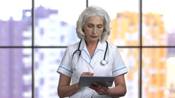 Viejo médico femenino deslizando tableta digital pc
. - Imágenes, Vídeo