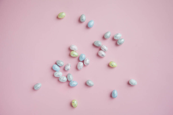 Пасхальные яйца, раскрашенные серебром на розовом фоне, подготовка к празднику, покраска пасхальных яиц
 - Фото, изображение