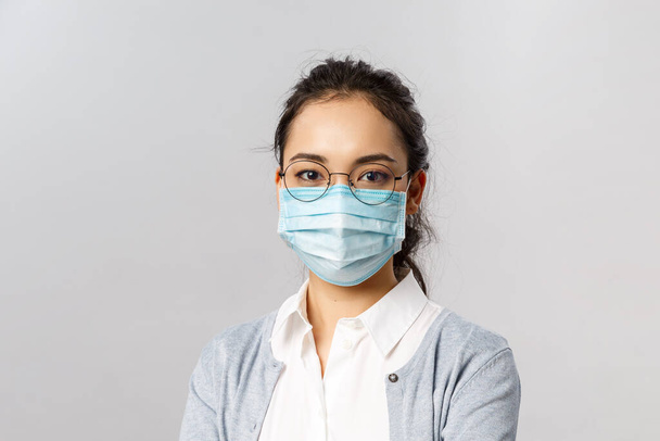 Covid19 、ウイルス、健康と医学の概念。コロナウイルスに感染しないように医療面マスクを着用した若いアジア人女性の肖像,隔離中に安全な家に滞在,パンデミア - 写真・画像