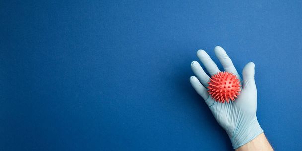 Ruku v ruce sterilní rukavice studuje maketu viru - Fotografie, Obrázek