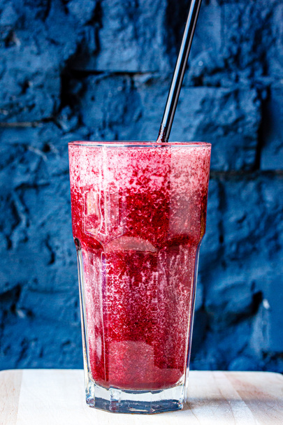 Piros bogyó smoothie egy nagy üveg ellen sötét kő fal - Fotó, kép
