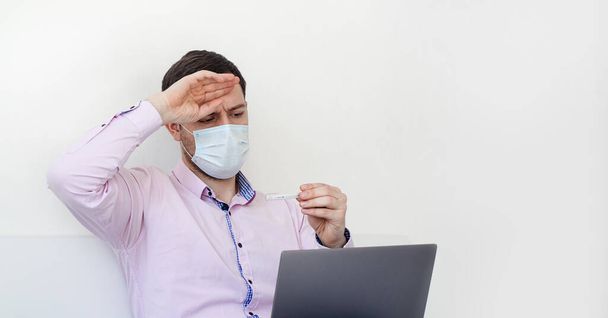 Coronavirus. Quarantine. A man in a shirt measures the temperature. High temperature. Virus protection. Coronavirus pandemic in the world. - Фото, зображення