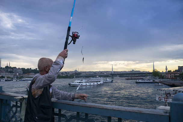 Süleymaniye-Moschee auf dem Hintergrund von Angelhaken. Fischer an der Galata-Brücke, Fischer fischen in Istanbul am 28. Juni. Türkei 2018 - Foto, Bild