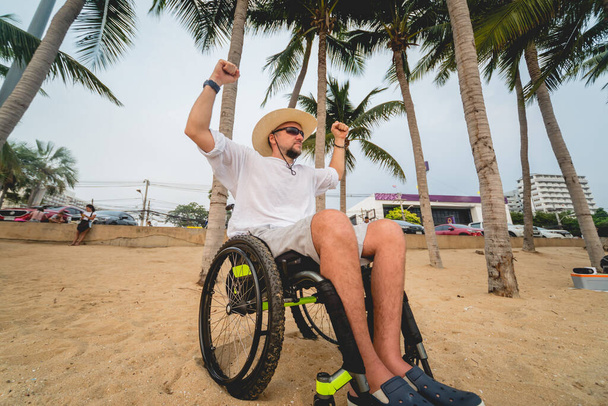 Disabled man in a wheelchair on the beach. - Fotoğraf, Görsel