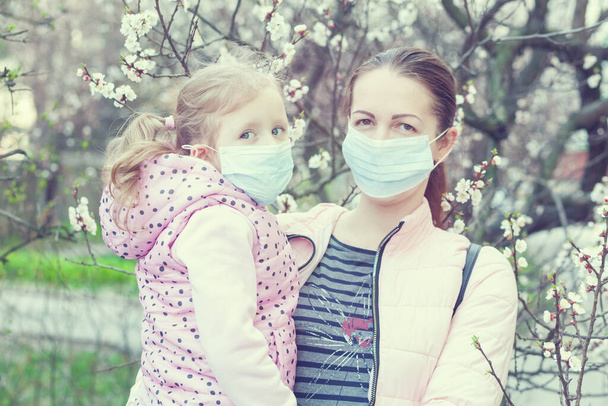 Fille et mère portant des masques dans la rue. Virus pandémique
. - Photo, image