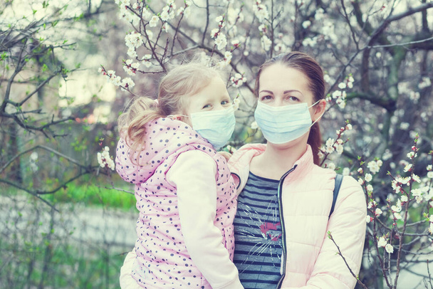 Figlia e madre che indossano maschere per strada. Virus pandemico
 - Foto, immagini
