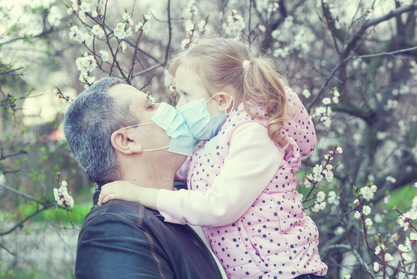 Daughter and dad wearing masks on the street. Pandemic virus. - Foto, immagini