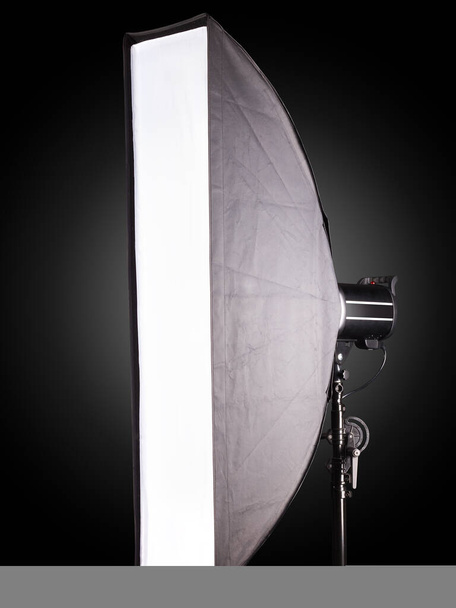 Fotografiestudio flitser met softbox geïsoleerd op zwarte achtergrond met lamp. Apparatuur zoals monobloc of monolight - Foto, afbeelding
