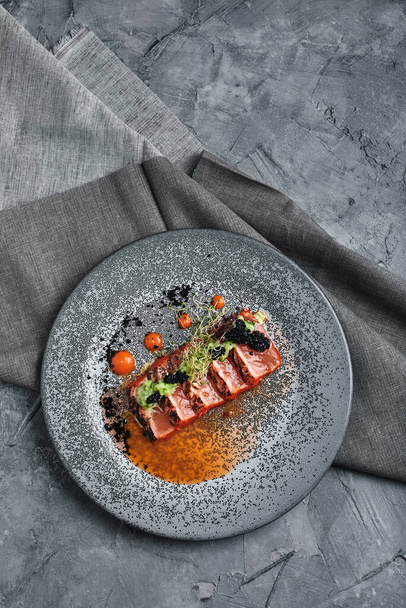 смажений вид лосося з тагліатою зверху, красиве накриття столу, чудова подача, традиційна італійська їжа, сірий фон, копіювальний простір. Концепція їжі - Фото, зображення