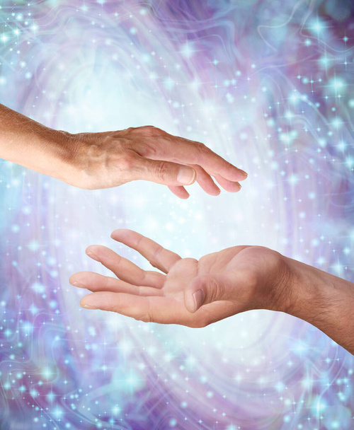 Pure Healing Mannelijke en vrouwelijke yin en yang energie - mannelijke hand tegenover vrouwelijke hand met een witte lichtbol ertussen tegen een paars blauwe wervelende sprankelende energie veld achtergrond  - Foto, afbeelding